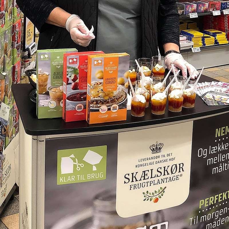 Svängd utställningsdisk med bordsskiva i trälook